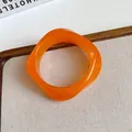 Macro detail of translucent orange acrylic bracelet with retro irregular wavy design - Translucent Orange
