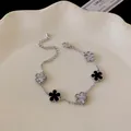 Close-up of elegant flower bracelet with black enamel and silver textured petals - Five-Flower Style / Silver-Black