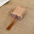 Macro view of an elegant silk jewelry box featuring a feather pattern and a long brown tassel - Ring Box (AQ127)