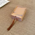 Close-up of elegant bronze jewelry box with silk tassel and feather pattern fabric - Necklace Pendant Box (AQ127)