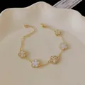 Detail view of gold-plated bracelet featuring white and gold flower charms - Five-Flower Style / Gold-White