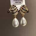 Close-up detail of zebra head earrings with sparkling zircons and white drop pearls - Gold Black (42#)