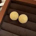Macro view of sparkling textured golden ball stud earrings in a brown velvet jewelry box. - Gold (44#)