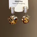 Detail view of amber gemstone earrings with sparkling zircon accents and gold-toned finish - Silver Coffee (46#)