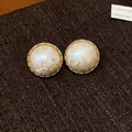 Detalle de pendientes redondos bañados en oro con elegantes perlas de algodón blancas. - Ola Redonda / Poste de pendiente de plata chapado en oro real / Beige