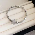 Bracelet élégant en perles grises avec un pendentif papillon en cristal pour femme. - Style Perle avec Pendentif Papillon (49#) / Argent-Gris