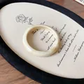 Macro view of an irregular cream-colored marbled resin bangle on a vintage-style fabric board - Creamy Irregular Thin Style 5