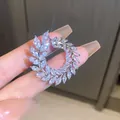 A detailed macro view of a sparkling zircon wreath brooch with premium silver plating - Silver