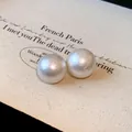 Detailed close-up showing the unique texture of white cotton pearl stud earrings for women - 20mm / White