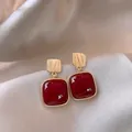 Elegant vintage red square stud earrings with textured gold-toned posts on silk - Square Stud Style