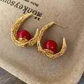 Elegant gold-tone woven U-shaped hoop earrings featuring a glossy vibrant red bead accent - Gold Red Real Gold Plating (60#)