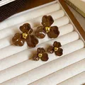 Vue détaillée de boucles d'oreilles en forme de fleurs brunes en deux tailles différentes - 3# Café - Grandes et Petites Fleurs