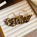 Vue détaillée de créoles fleurs léopard avec perles sur velours beige - 7# Or - Créole Léopard Perle