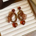 Vue détaillée des boucles d'oreilles cœur ambre style Maillard avec fleurs en tissu - 6# Café - Pendentif Pétale de Coeur