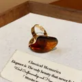 Close-up of a vintage amber resin oval open ring on a textured display card - Oval Open Ring / Amber