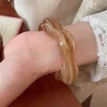 Minimalist amber marble texture acrylic wavy open bangle bracelet shown on wrist - Wave Amber Pattern (HB3743-1) / Brown