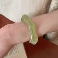 Irregular wavy light green acrylic bangle shown on wrist for a minimalist niche style look. - Wave Shape (HB3743-1) / Light Green