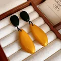 Primer plano de pendientes de madera vintage en amarillo mostaza y negro con gota - Estilo de Pasador de Plata / Dorado-Negro