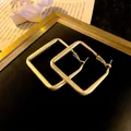 Elegant matte gold geometric square hoop earrings with a modern brushed metal finish. - Square Hoop Earrings