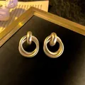 Elegant matte gold geometric double hoop stud earrings for a sophisticated fashion look - Double Interlocking Hoop