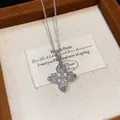 Vista dettagliata di una collana con ciondolo floreale a croce in zircone in un portagioie - Argento