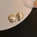 Elegant golden brushed metal sphere stud earrings featuring minimalist geometric style - Golden Geometric Circle