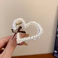 Close-up detail of a heart-shaped acrylic hair claw clip filled with beige mini pearls - Beige Heart Shaped Heart Bow Claw Clip (57#)