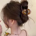 Minimalist brown heart hair claw clip with colorful polka dots shown on woman's bun - Polka Dot Heart Style / Amber Polka Dot