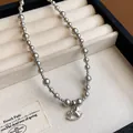 Detailed view of an elegant silver beaded necklace featuring a charming rocking horse pendant - Gray