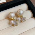 Detailansicht vergoldeter Sternohrringe mit strukturierten Perlen und Zirkonia. - Stern Ohrstecker / Gold-Beige