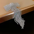 Detailed close-up of a sparkling rhinestone bow hair clip featuring elegant long tassel drops - Spring Clips / Silver