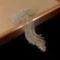 Close-up of sparkling rhinestone bow hair clip with elegant long tassel fringe detail - Spring Clips / Gold