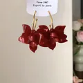 Detailansicht der Vintage-Ohrringe mit roten Harzblumen und goldfarbenen Creolen - Rot