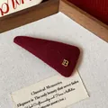 Close-up of a deep red plush triangular hair clip featuring a golden B-logo detail. - Metal Letter B Triangle BB Clip