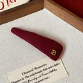 Close-up of a burgundy plush triangle hair clip with a golden 'B' letter detail. - Metal Letter B Knitted BB Clip