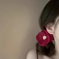 Elegant dark red camellia flower hair clip worn by a model for a stylish, chic hairstyle - Camellia Pattern / Red