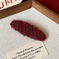 Close-up detail of the deep red plush texture of this elegant knitted hair clip - Oval Plush Hair Clip