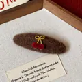 Close-up of brown plush hair clip with gold bow and red cherry detail - Cherry Bow Decor Oval BB Clip