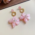 Detail view of pink resin flower drop earrings with shimmering crystal centers - Pink