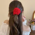 Elegant handmade red fabric rose flower hair scrunchie accessory on long wavy brown hair - Fabric Rose Scrunchie Style / Red