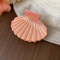 Pearlescent pink shell-shaped hair claw clip on wooden background with soft fabric - S / Orange