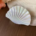 Macro view of an iridescent seashell hair claw clip with a glossy mother-of-pearl finish - L / Cyan