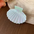 Close-up of an iridescent shell-shaped hair claw clip with a pearlescent finish - S / Light Blue