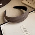 Gros plan sur un serre-tête en tissu rayé marron avec détails de tissage élégants. - Marron