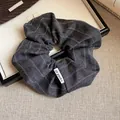 Gros plan d'un chouchou élégant en tissu à rayures grises avec une texture d'automne - Gris