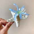 Close-up macro view of a starfish hair clip featuring delicate blue fabric flower petals - Blue Starfish Flower (HH8278)