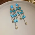 Close-up of bohemian turquoise teardrop tassel earrings with silver rhinestone accents. - Silver And Blue (HE24623)