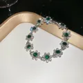 Macro view of French vintage floral bracelet with green gems and white diamonds - Bracelet - Silver - Green