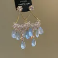 Close-up of elegant ethnic style earrings featuring light blue water-drop tassels and crystals. - Style 14 Silver Pin Gold Blue