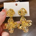 Elegant textured gold flower statement earrings with vintage metallic finish for women. - Silver Post Style (HE9435) / Gold